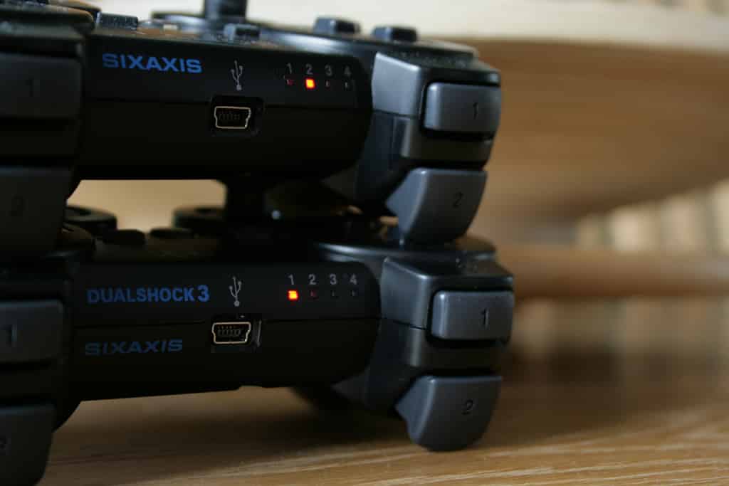 Sixaxis, o controle original do PS3 (em cima) e um DualShock 3, com vibração (em baixo). Externamente, são muito parecidos.