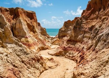 No litoral, uma cidade guarda um labirinto de areia colorida que a chuva e o vento redesenham