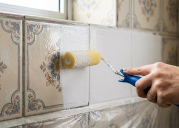 Pintor que trabalha com tinta epóxi separa onde a pintura de azulejo aguenta e onde ela descasca, parede seca fora do box segura bem, faixa acima da bancada também, piso e área interna do box não seguram, e azulejo solto inviabiliza o serviço inteiro
