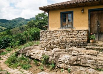 A vila do interior de Minas onde as casas foram erguidas sobre pedra viva e o pedreiro local ensina o encaixe que dispensa fundação há mais de um século