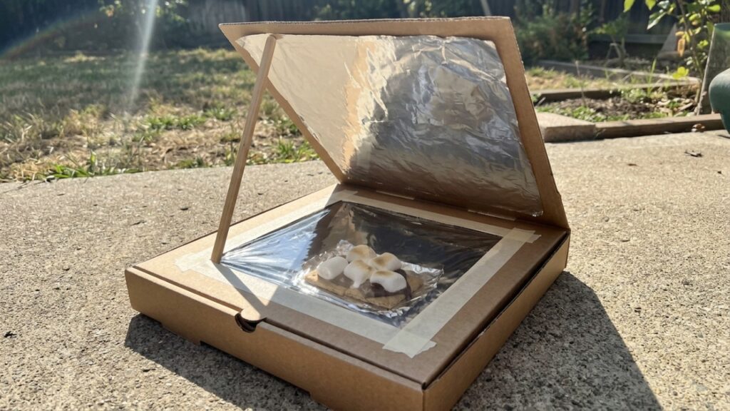 A invenção caseira com uma caixa de pizza, papel-alumínio e plástico transparente que transforma a luz do sol em um pequeno forno solar para aquecer alimentos