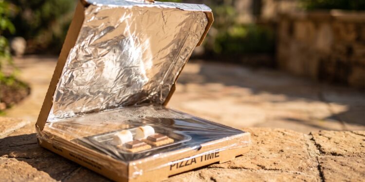 A invenção caseira com uma caixa de pizza, papel-alumínio e plástico transparente que transforma a luz do sol em um pequeno forno solar para aquecer alimentos