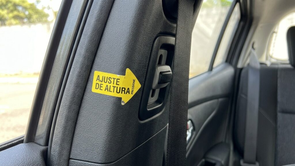 Para que serve a seta no símbolo do cinto de segurança do banco de trás e por que ela muda a altura correta da faixa no ombro