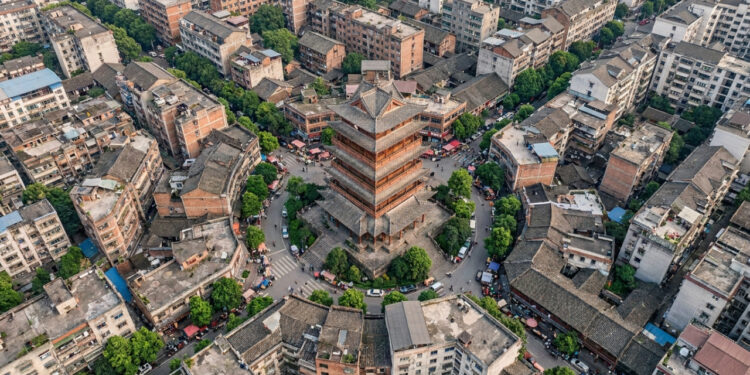Vista do alto, uma cidade chinesa revela ruas inteiras convergindo para uma única torre vermelha no coração do centro antigo
