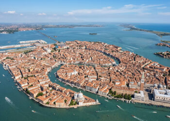Vista do alto, uma cidade europeia parece um peixe sobre a água, espalhada por cerca de cem ilhas e cortada por canais