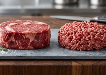 Comparação entre carne bovina em peça inteira e carne moída sobre uma bancada refrigerada, destacando a diferença de textura e superfície. - (Imagem gerada por inteligência artificial-ChatGPT/Olhar Digital)