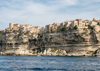 Uma cidade francesa termina praticamente na borda de falésias calcárias de cerca de 100 metros, com casas e uma cidadela olhando para o Mediterrâneo