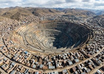 Vista aérea de Cerro de Pasco, no Peru, com uma enorme mina a céu aberto cercada por bairros e montanhas dos Andes. - (Imagem gerada por inteligência artificial-ChatGPT/Olhar Digital)