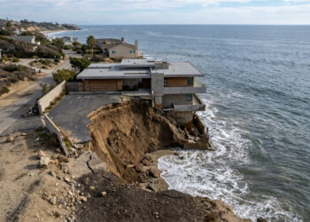 Ondas abriram um enorme buraco diante de uma casa à beira-mar, e imagens aéreas mostram a água avançando por baixo da construção