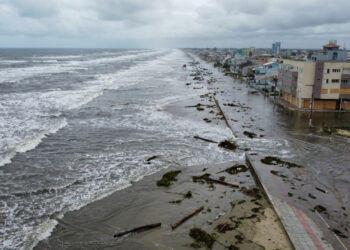 A cidade do Sul onde uma ressaca faz o oceano atravessar a praia, invadir a avenida, alcançar casas e mobilizar máquinas contra troncos e vegetação