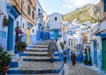 A cidade construída na encosta de uma montanha onde fachadas, vielas e escadarias foram tomadas por diferentes tons de azul e branco