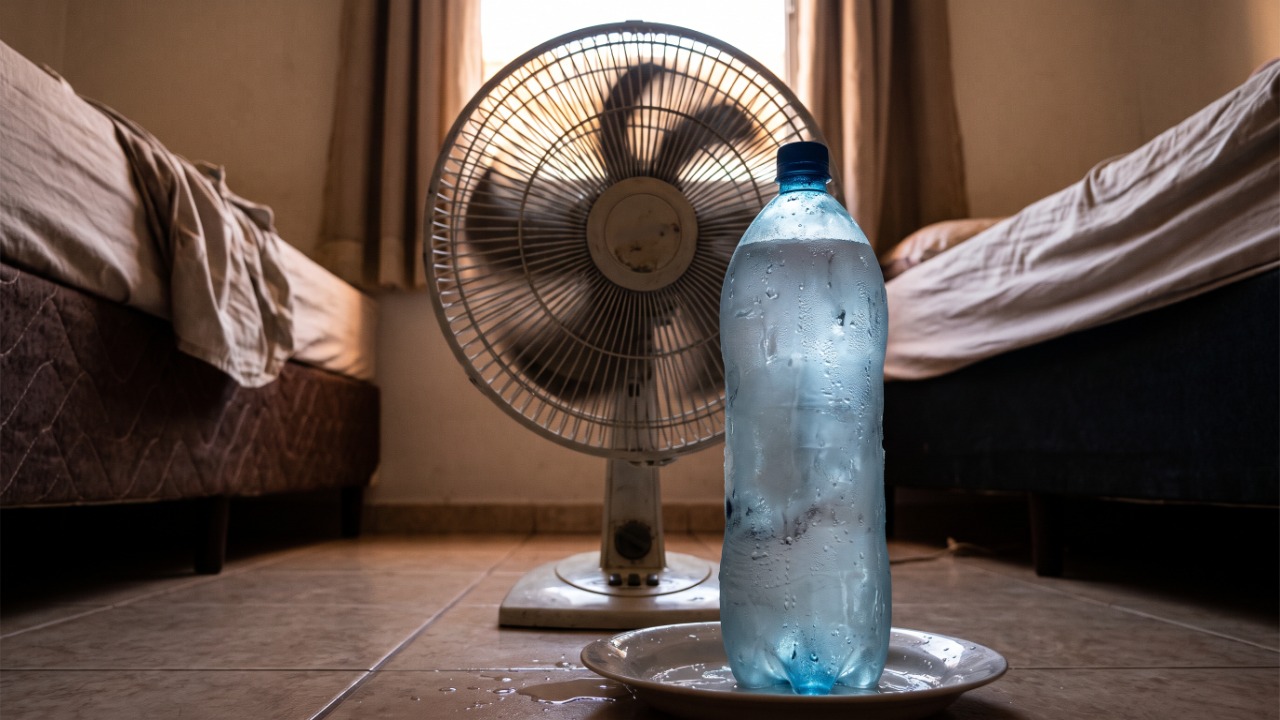 A gambiarra da garrafa congelada na frente do ventilador viralizou como “ar-condicionado caseiro”, e engenheiros explicam quantos graus ela realmente baixa no quarto