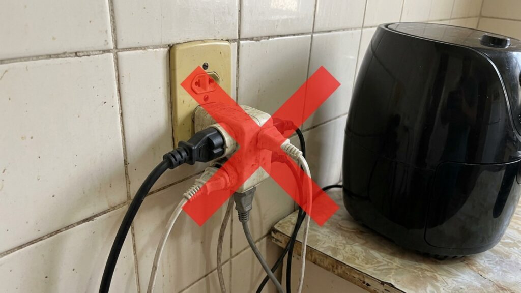 Eletricista que atende chamado de tomada derretida há anos repete o mesmo alerta: em 127 volts, uma air fryer de 1.500 watts já puxa quase 12 ampères, acima dos 10 ampères de um benjamim ou extensão comum