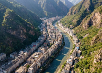 Vista do alto, uma cidade chinesa parece espremida entre duas montanhas, com trechos urbanos de apenas 30 metros de largura acompanhando um rio