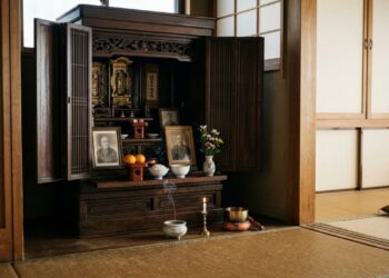 Altar doméstico japonês de madeira com fotografias de antepassados, incenso, oferendas e vela acesa em uma residência tradicional. (Imagem gerada por inteligência artificial-ChatGPT/Olhar Digital)