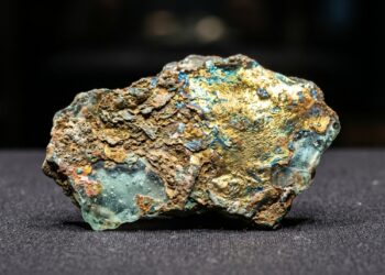 Fragmento de vidro romano de 2 mil anos com superfície dourada e iridescente formada pela corrosão ao longo dos séculos.