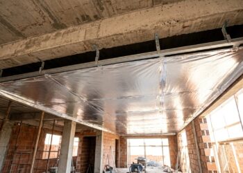 Manta térmica aluminizada prateada instalada abaixo de uma laje de concreto, com espaço de ar entre o material refletivo e a estrutura. - (Imagem gerada por inteligência artificial-ChatGPT/Olhar Digital)