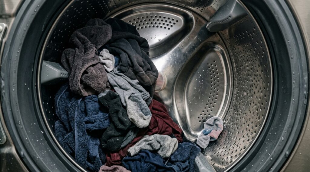 Roupas úmidas acumuladas em um lado do tambor de uma máquina de lavar antes da centrifugação. - (Imagem gerada por inteligência artificial-ChatGPT/Olhar Digital)