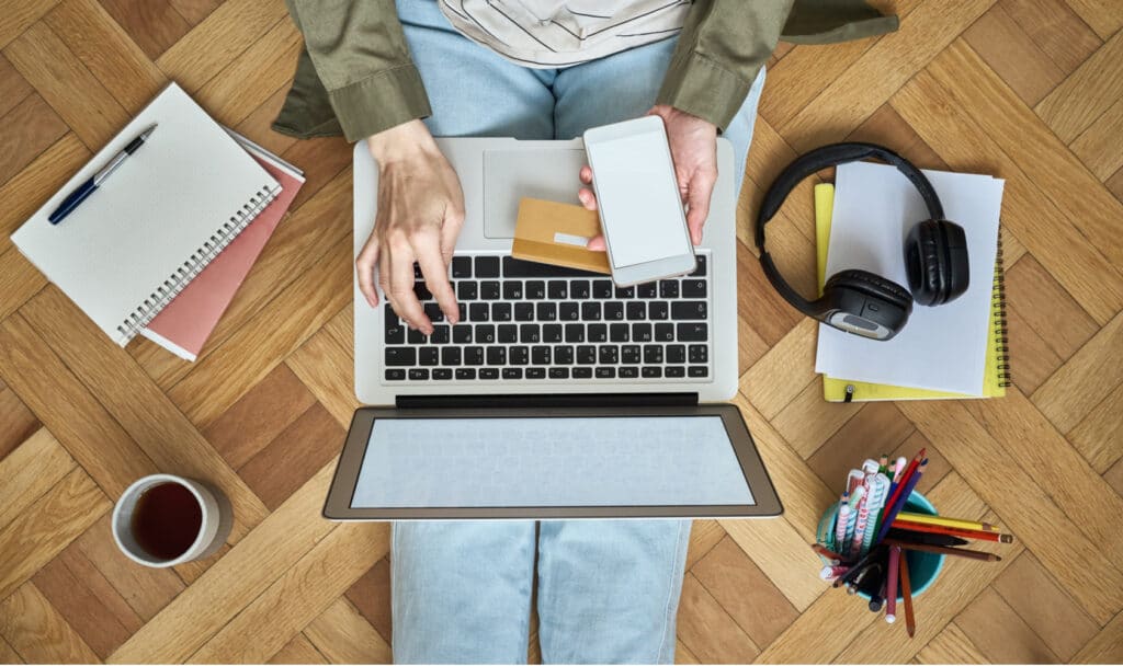 pessoa com computador no colo e acessórios em volta