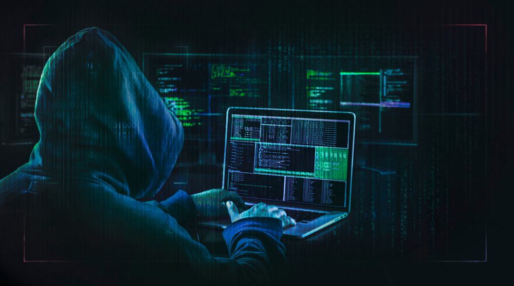 Imagem mostra um hacker visualizando dados privados, igual ao que fizeram com o Microsoft Outlook em março de 2021
