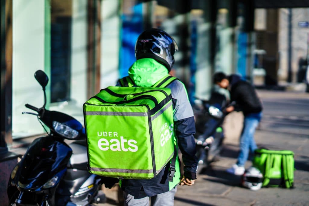 motoqueiro com container do uber eats