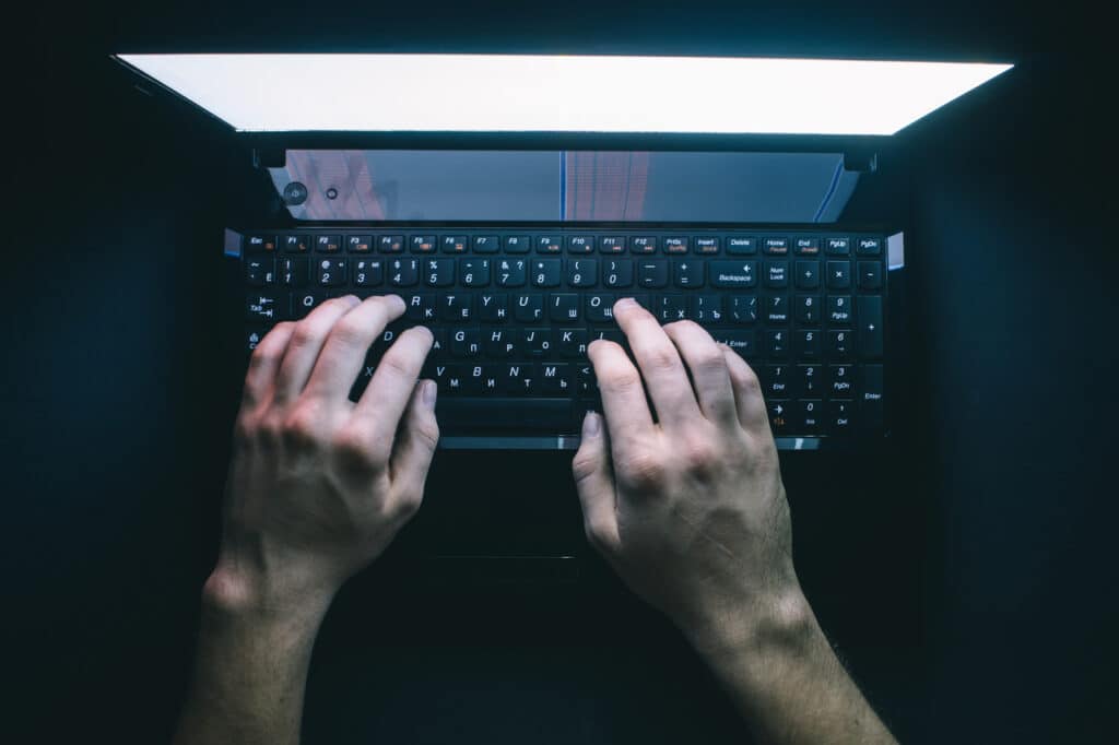 Hacker participando de um hackathon digitando no teclado de um notebook