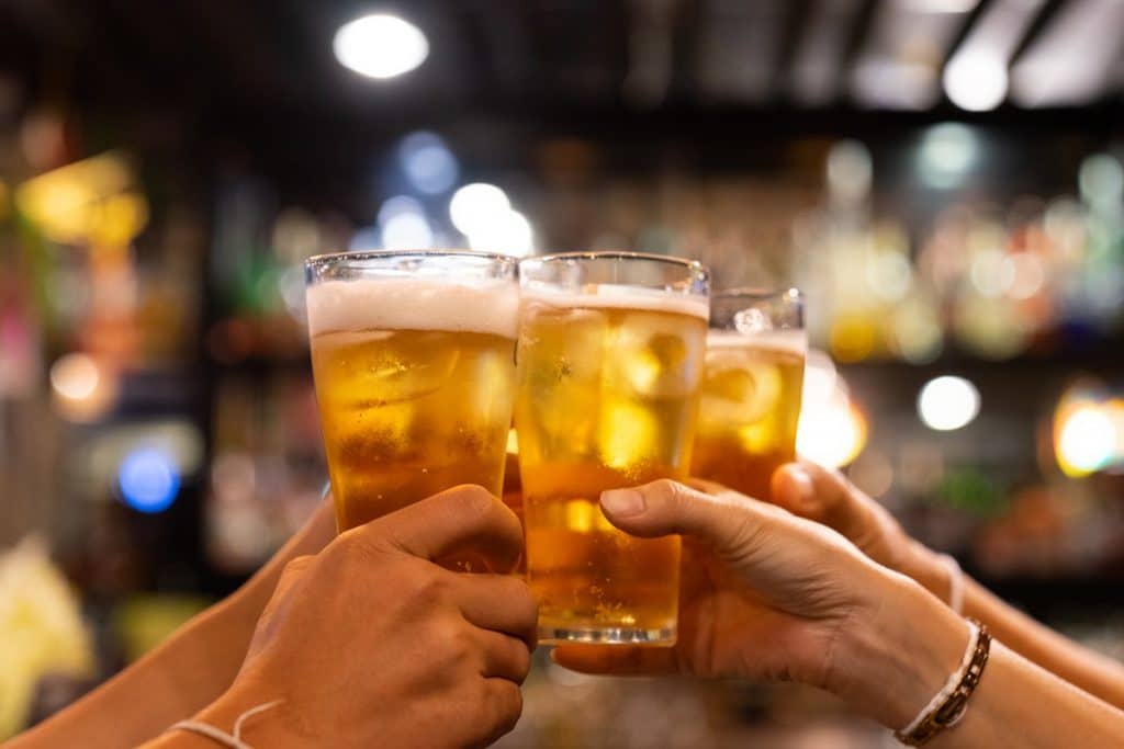 pessoas brindando com copos de cerveja