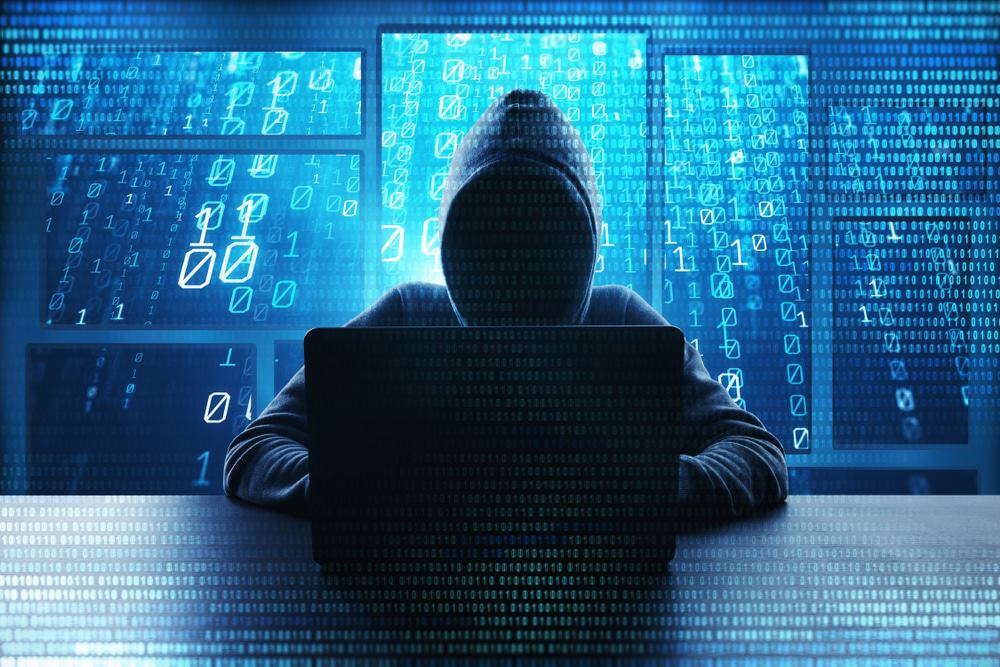 Imagem mostrando uma figura encapuzada, simbolizando um hacker nas sombras
