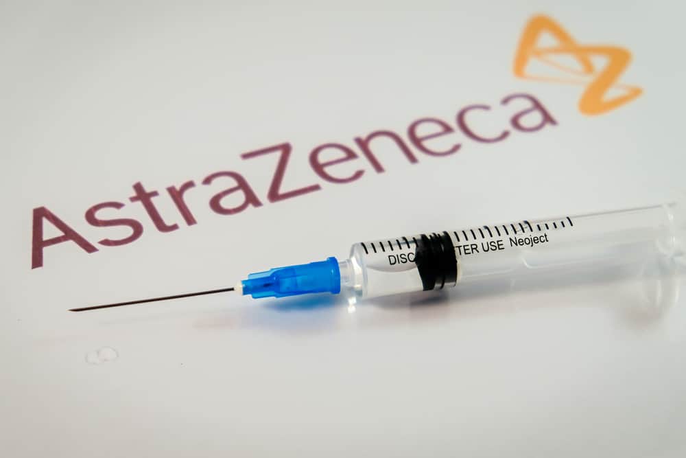 Logo da AstraZeneca com uma amostra de vacina contra a Covid-19