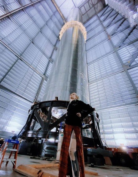 Grimes posa em frente a base espacial de Elon Musk. Imagem: Instagram