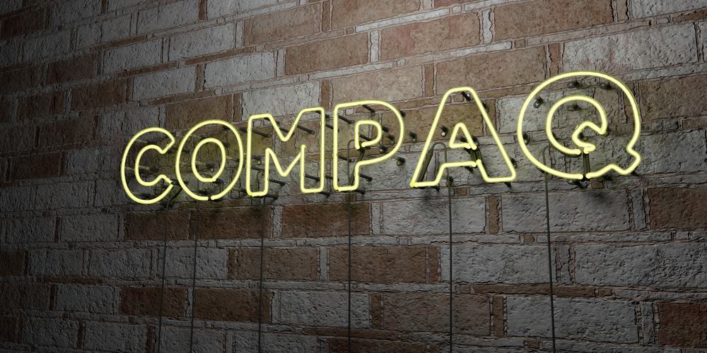 Em uma parede de tijolos é possível ler a palavra Compaq
