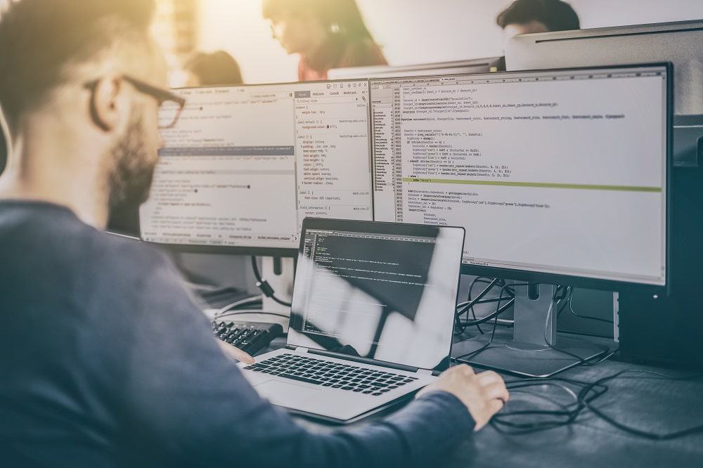 Imagem mostra um desenvolvedor escrevendo linhas de código no computador