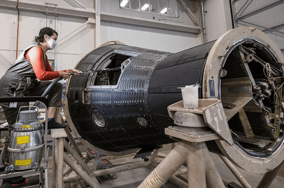Imagem mostra uma restauradora do Museu Smithsonian, incumbida de restaurar a primeira roupa do astronauta Alan Shepard, bem como a cápsula onde ele comandou a primeira viagem dos EUA ao espaço