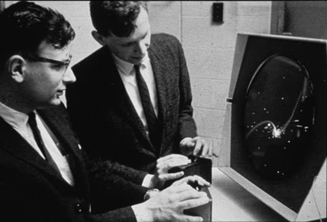 Estudantes do MIT jogando 'Spacewars!'. A foto não foi datada, mas a instituição acredita que deva ter sido tirada entre 1962 e 1965. Imagem: Institute Archives | Distinctive Collections - MIT Libraries/Reprodução
