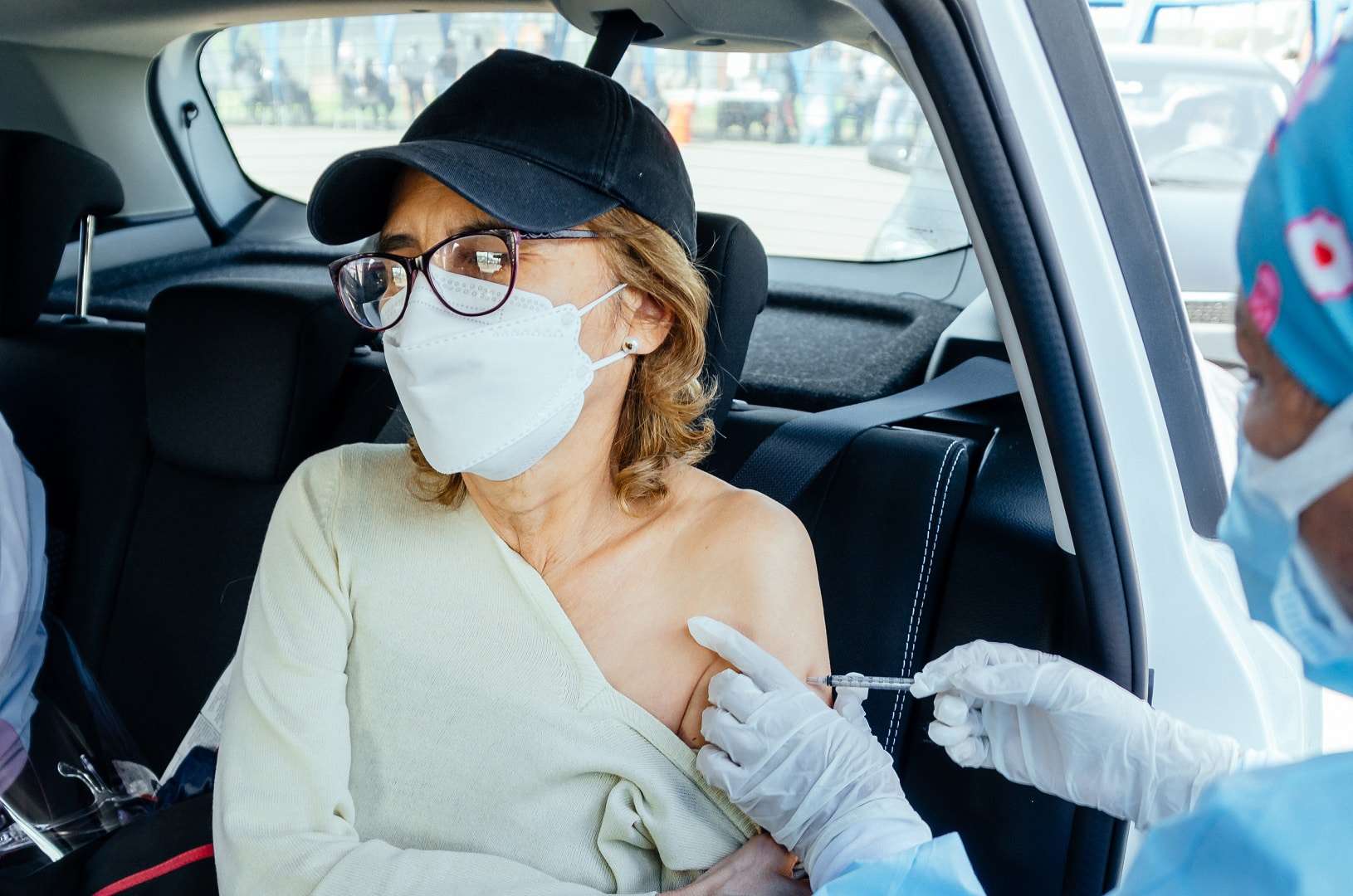Uma idosa recebendo a injeção da vacina contra o coronavírus por uma enfermeira
