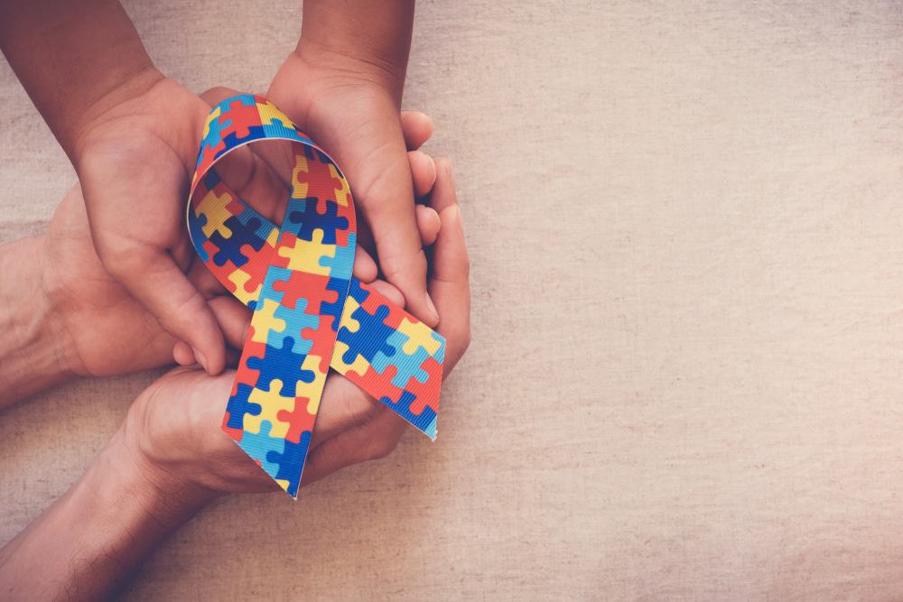 Mãos segurando uma fita estampada com um quebra-cabeça colorido