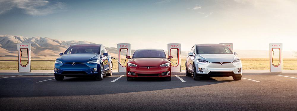 Três carros da Tesla sendo carregados