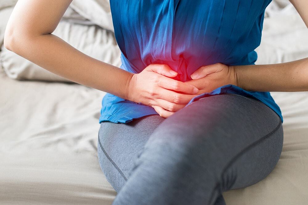 Mulher com cólica menstrual apertando a barriga