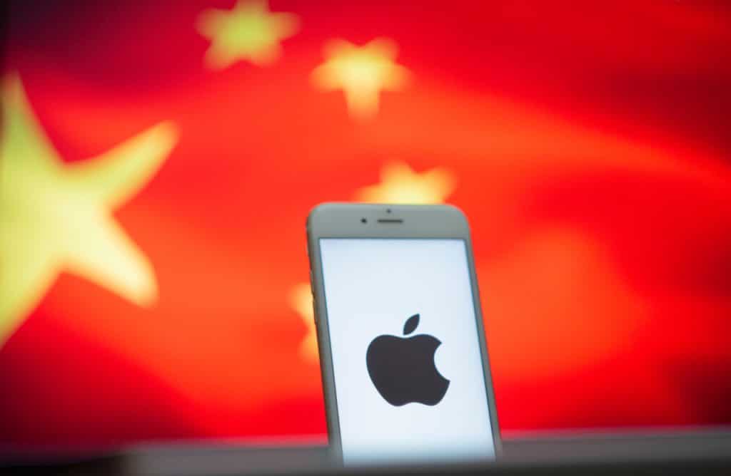 Apple desafia Trump e promete novos investimentos na China A nova escalada nas tensões entre Estados Unidos e China, com o presidente Donald Trump cogitando retomar tarifas contra o país asiático, deixa o mercado global em suspense. Neste cenário, muitas empresas norte-americanas simplesmente têm se afastado de Pequim. Um smartphone é exibido à frente da bandeira chinesa, com o logotipo da Apple em sua tela