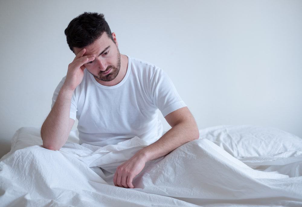 Homem sentado na cama