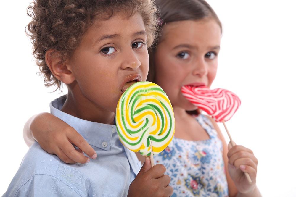 crianças comendo pirulito