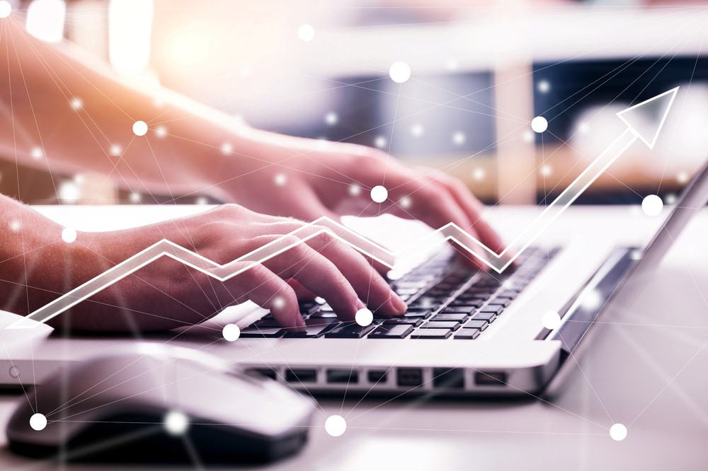 Imagem mostra um par de mãos digitando algo no teclado de um notebook