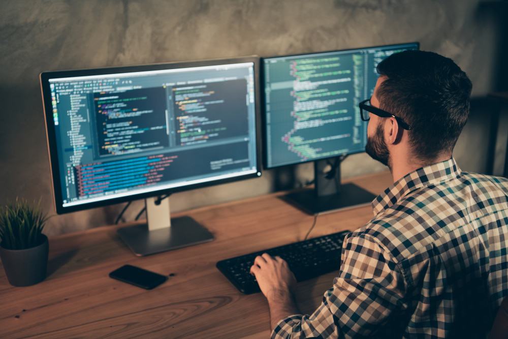 Profissional de TI programando em um computador.