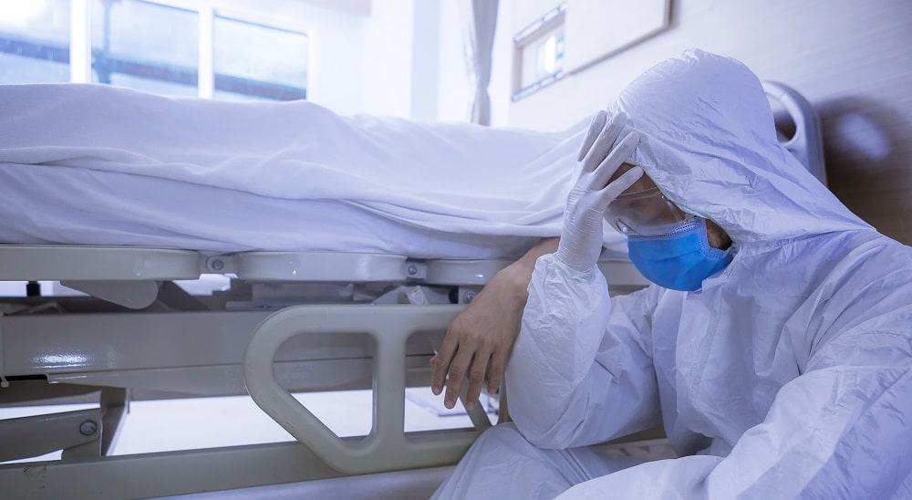 Médico ao lado de paciente morto por Covid-19