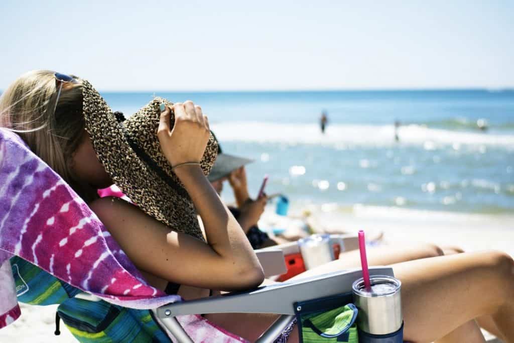 Mulher na praia tomando sol