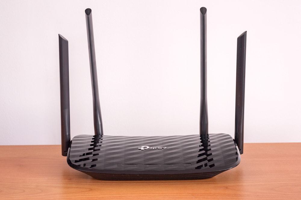 Roteador TP-Link preto com quatro antenas 