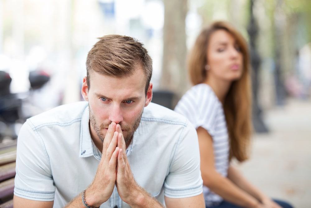 Homem em primeiro plano e mulher desfocada