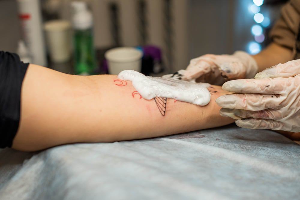 Tatuador lavando tatuagem 