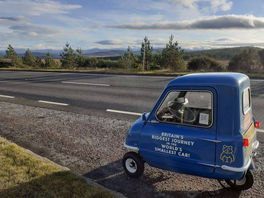 Menor carro do mundo à beira de uma estrada