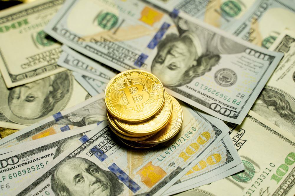 Moedas de bitcoin com notas de dólar.